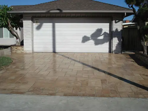 Stamped and stained concrete driveway in front of a garage